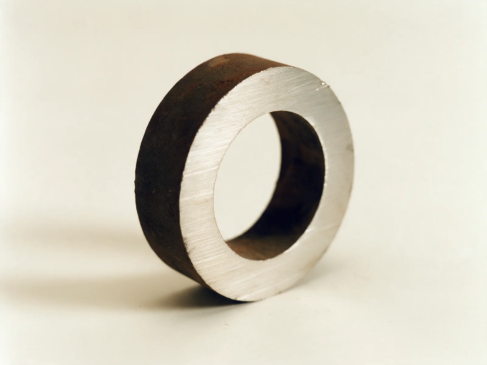 A ring cut from a retired alloy tube, showing bright metal beneath the oxidised wall